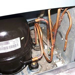 The copper lines are inserted into the compressor.